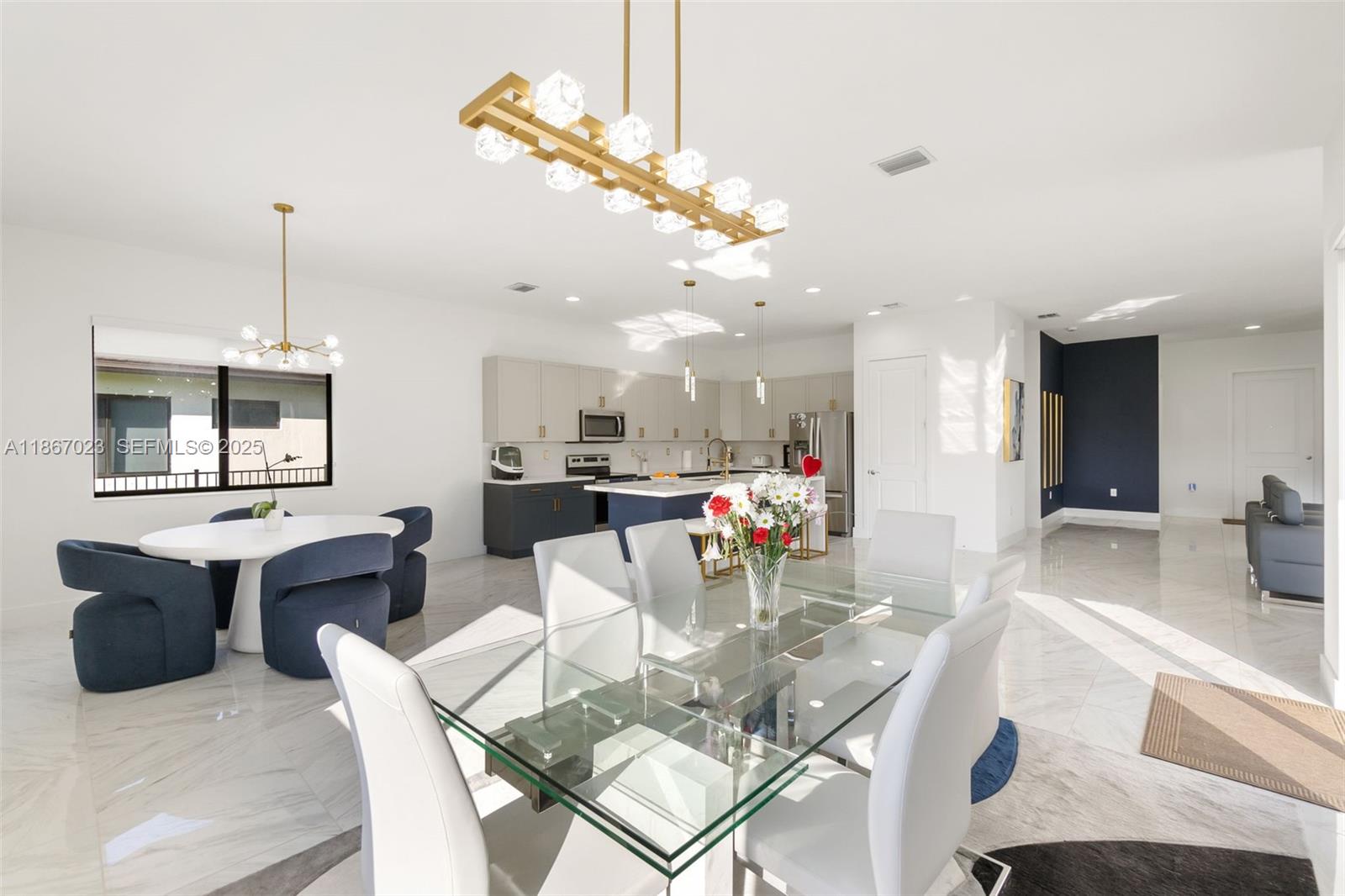 4948 Gambero Way Ave Maria, FL 34142 - Photo 3 of 28 a dining room with wooden floor a chandelier a glass table and chairs