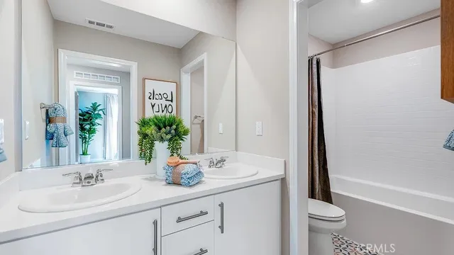 a bathroom with a sink a toilet and a mirror