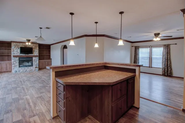a kitchen with a stove a sink a window and chairs