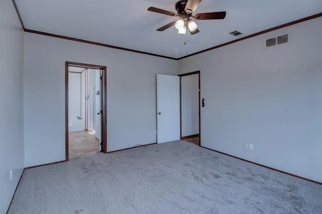 an empty room with a ceiling fan and a window