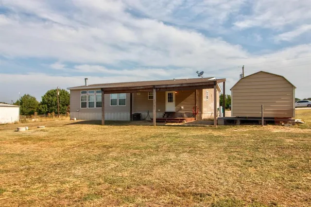 front view of a house with a yard and potted plants