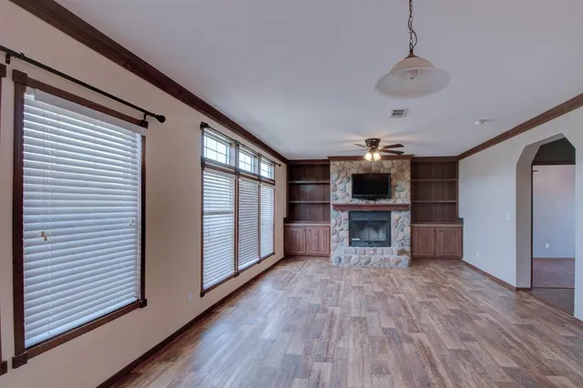 a view of a livingroom with a fireplace wooden floor and window