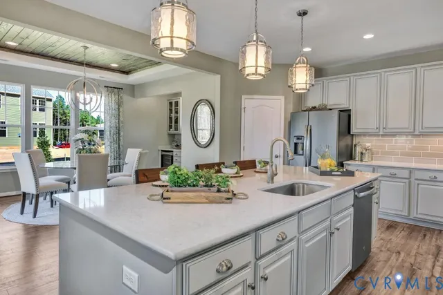 a kitchen with stainless steel appliances granite countertop a sink a stove and a refrigerator
