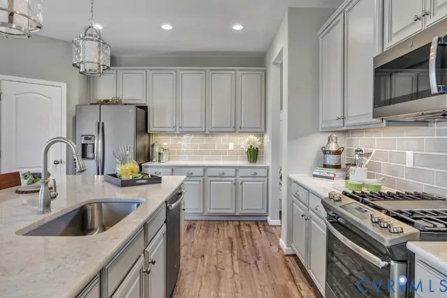 a kitchen with stainless steel appliances granite countertop a sink stove and refrigerator