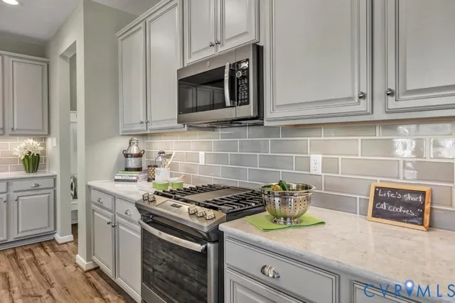 a kitchen with granite countertop stainless steel appliances a stove a microwave and cabinets