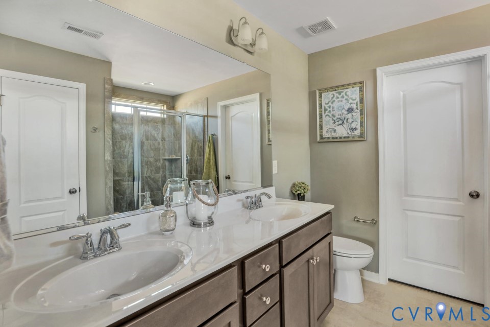 985 Charlemagne Road Midlothian, VA 23114 - Photo 23 of 42 a bathroom with a granite countertop sink a toilet and a large mirror