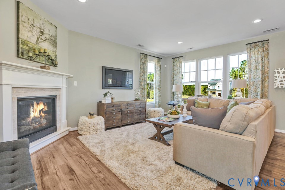 985 Charlemagne Road Midlothian, VA 23114 - Photo 7 of 42 a living room with furniture a fireplace and a flat screen tv