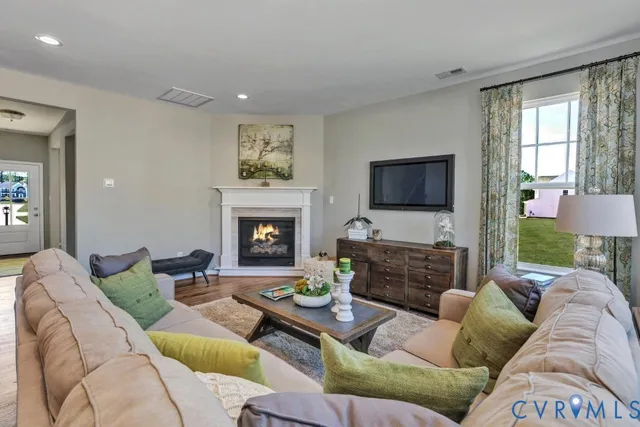 a living room with furniture a flat screen tv and a fireplace