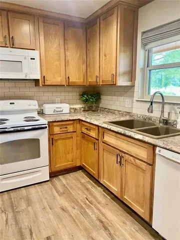 a kitchen with granite countertop white cabinets and white appliances