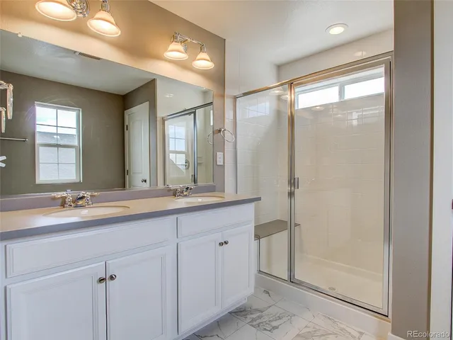 a bathroom with double sink and a mirror