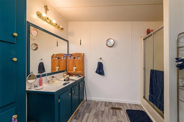 a bathroom with a sink a mirror and shower