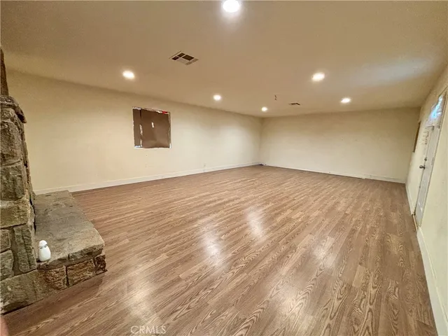 an empty room with wooden floor and a bathroom