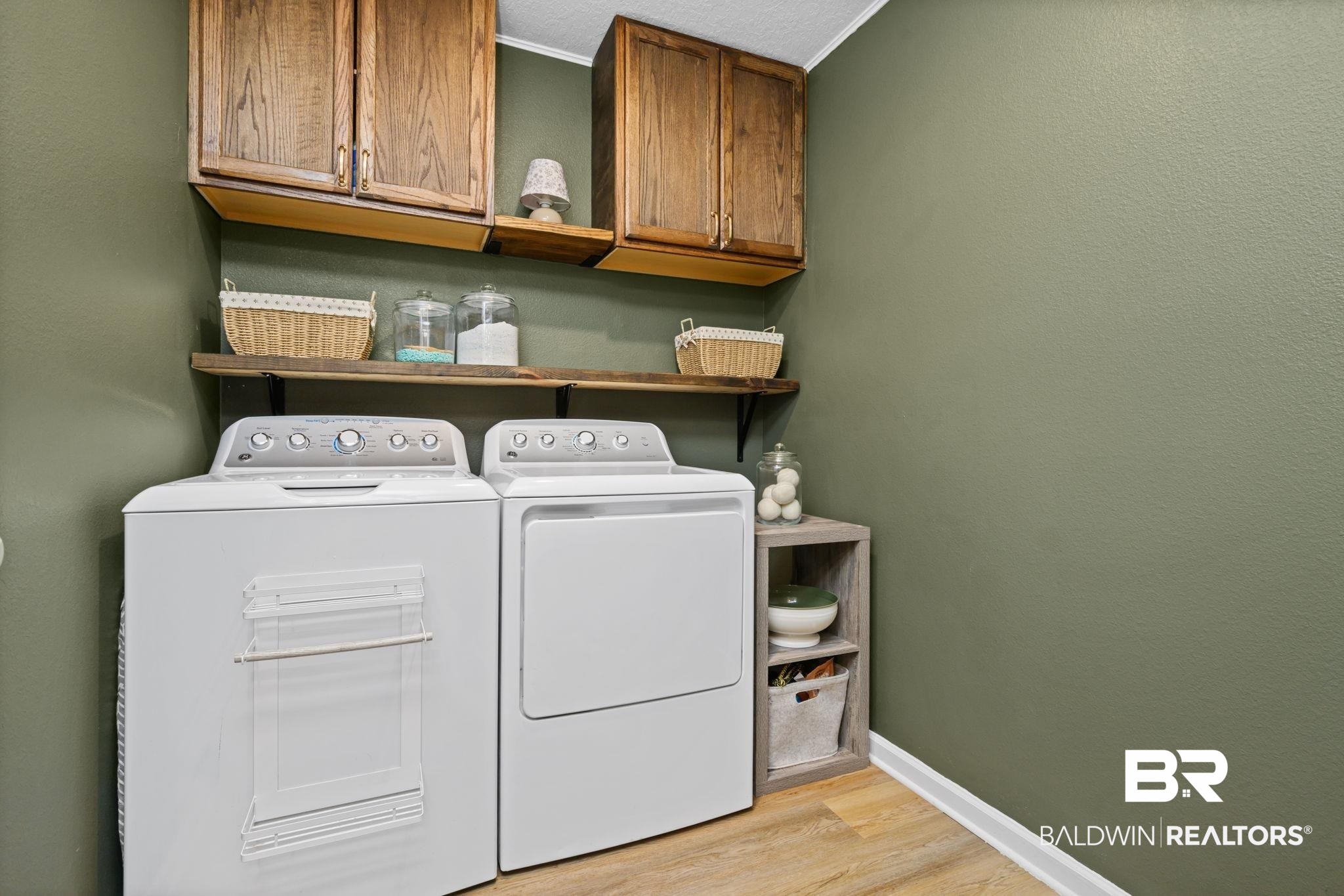 8021 Valor Rdg Way North Mobile, AL 36619 - Photo 16 of 34 Dedicated laundry space featuring wood-finish flooring, olive green wall paint, and white baseboards