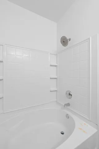 a white bath tub sitting next to a white sink and vanity