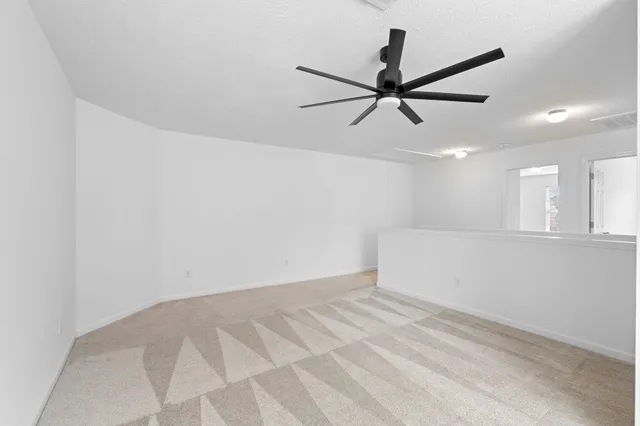 a view of a big room with wooden floor and windows