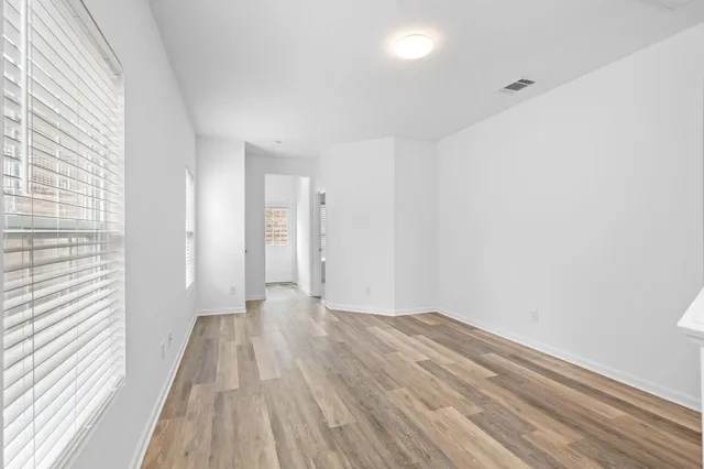 a view of a room with wooden floor and white walls