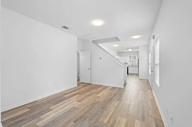 a view of a hallway with wooden floor
