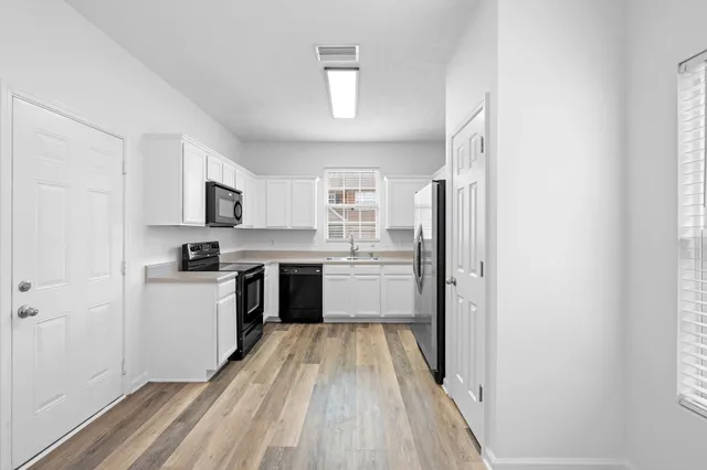 a kitchen with stainless steel appliances a refrigerator sink and stove