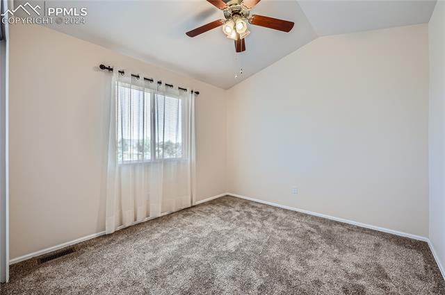12510 Motley Road Peyton, CO 80831 - Photo 22 of 36 Carpeted spare room with vaulted ceiling and ceiling fan