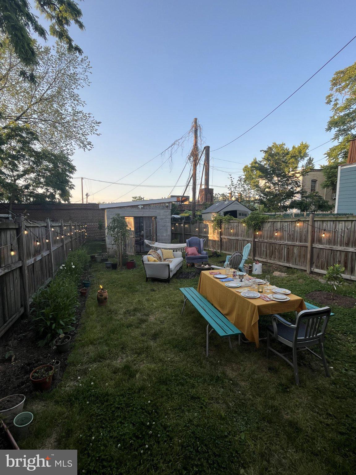 1238 U Street Southeast Washington, DC 20020 - Photo 9 of 12 Charming backyard gathering at dusk.