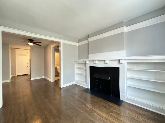 a view of an empty room with a fireplace and a window