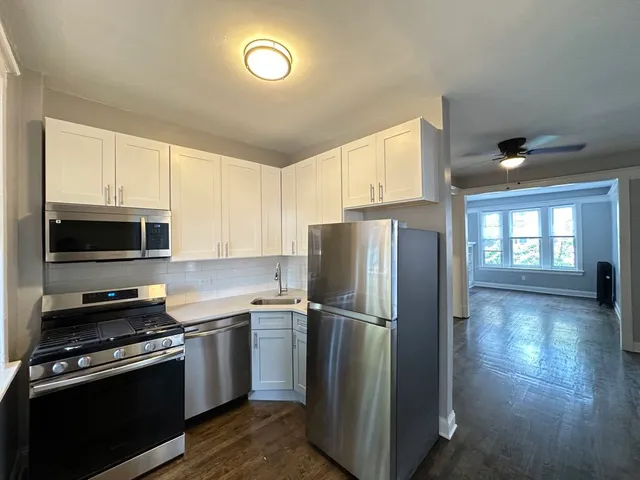 a kitchen with a refrigerator sink and cabinets