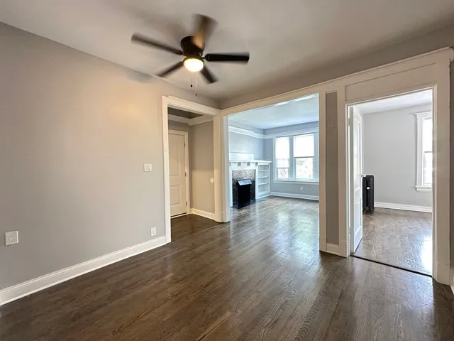 a view of a livingroom with wooden floor and a ceiling fan