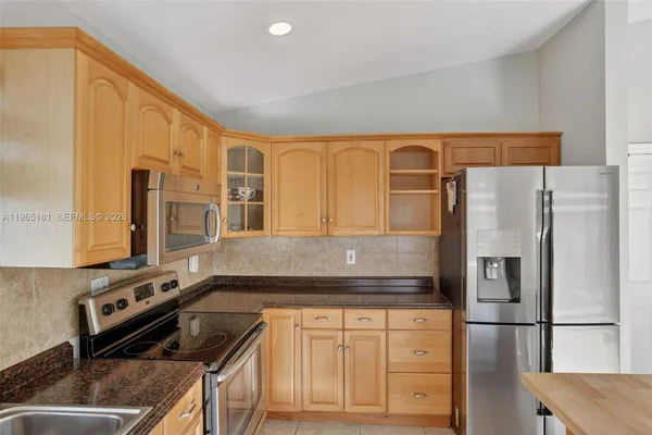 a kitchen with stainless steel appliances granite countertop a refrigerator and a stove