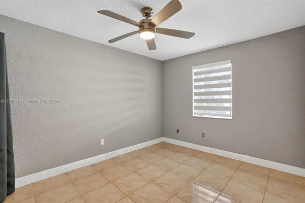a view of a room with a ceiling fan and window