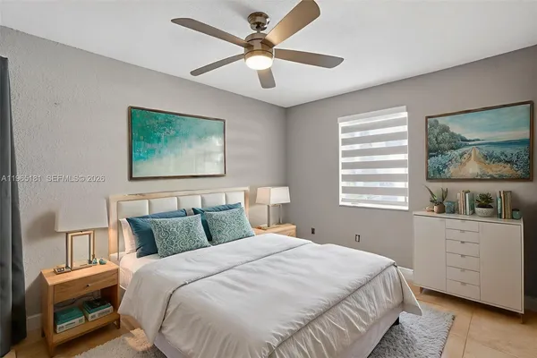 a bedroom with a bed a dresser next to a window