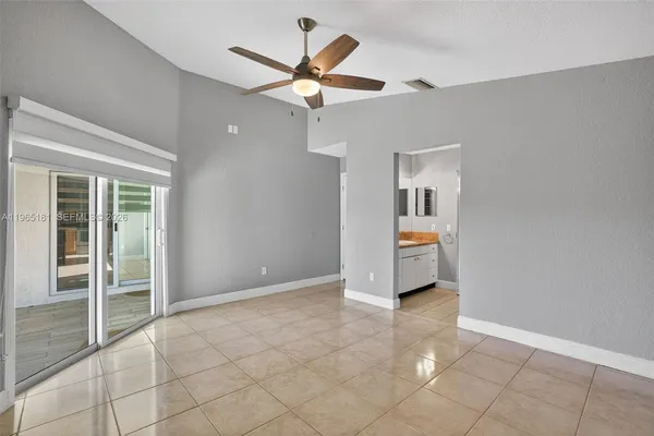 an empty room with fan and windows