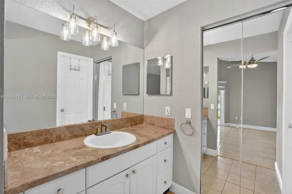a bathroom with a granite countertop sink a mirror and a shower