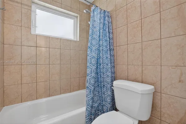 a white toilet sitting next to a bath tub and shower