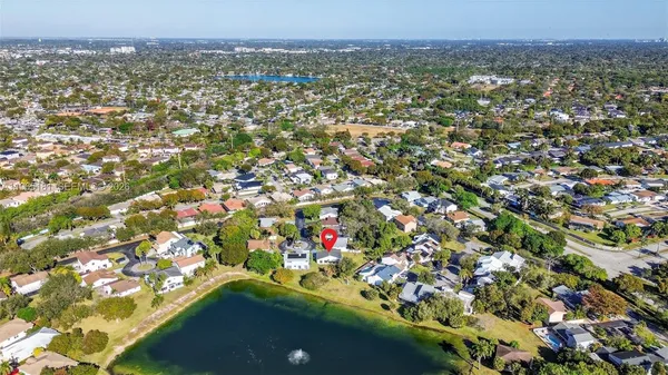 an aerial view of residential houses with outdoor space and trees