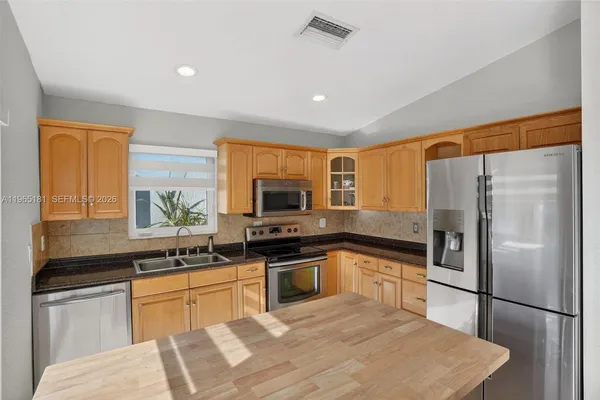 a kitchen with a refrigerator stove and sink