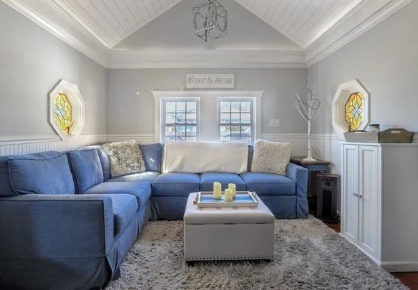 a living room with furniture a chandelier and a window
