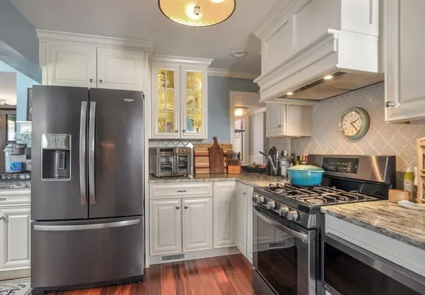 a kitchen with stainless steel appliances granite countertop a stove a refrigerator and a sink