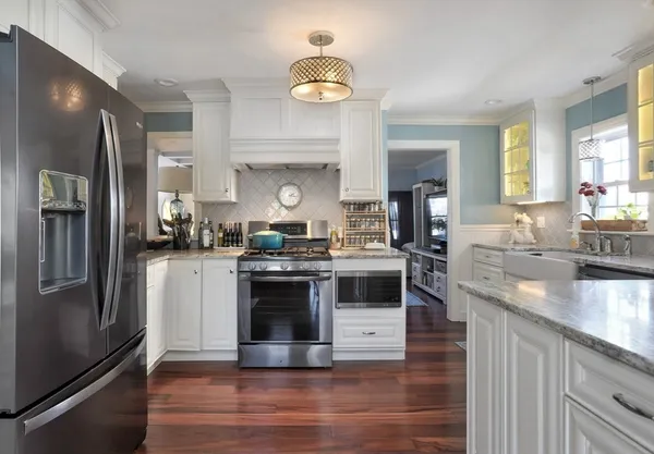 a kitchen with stainless steel appliances granite countertop a stove a refrigerator and a sink