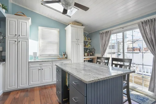 a kitchen with granite countertop a stove a sink and wooden cabinets