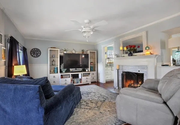 a living room with furniture a flat screen tv and a fireplace