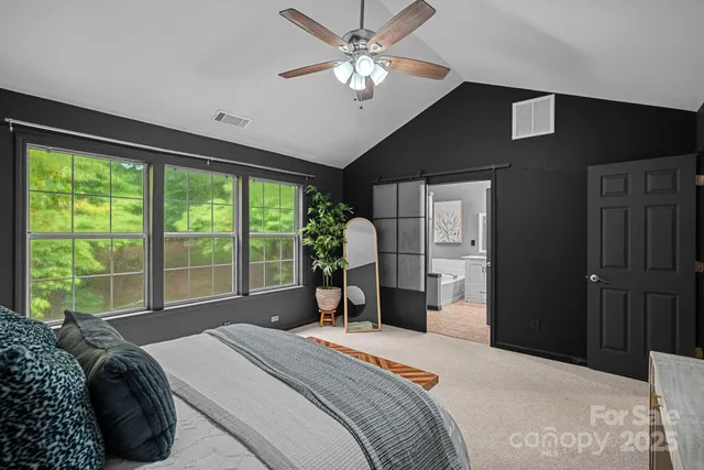 a bedroom with a bed and a large window