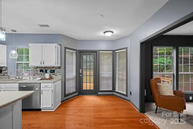 a large white kitchen with cabinets a sink and a refrigerator