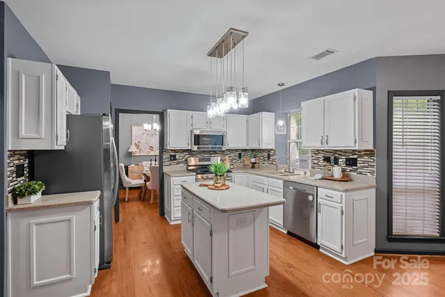 a kitchen with stainless steel appliances stove refrigerator and cabinets