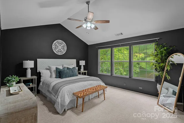 a bedroom with a bed and a large window