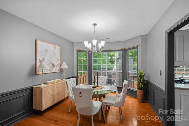 a view of a dining room with furniture a chandelier and wooden floor
