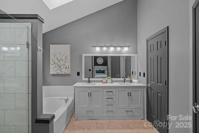 a bathroom with a double vanity sink a mirror a bathtub and shower