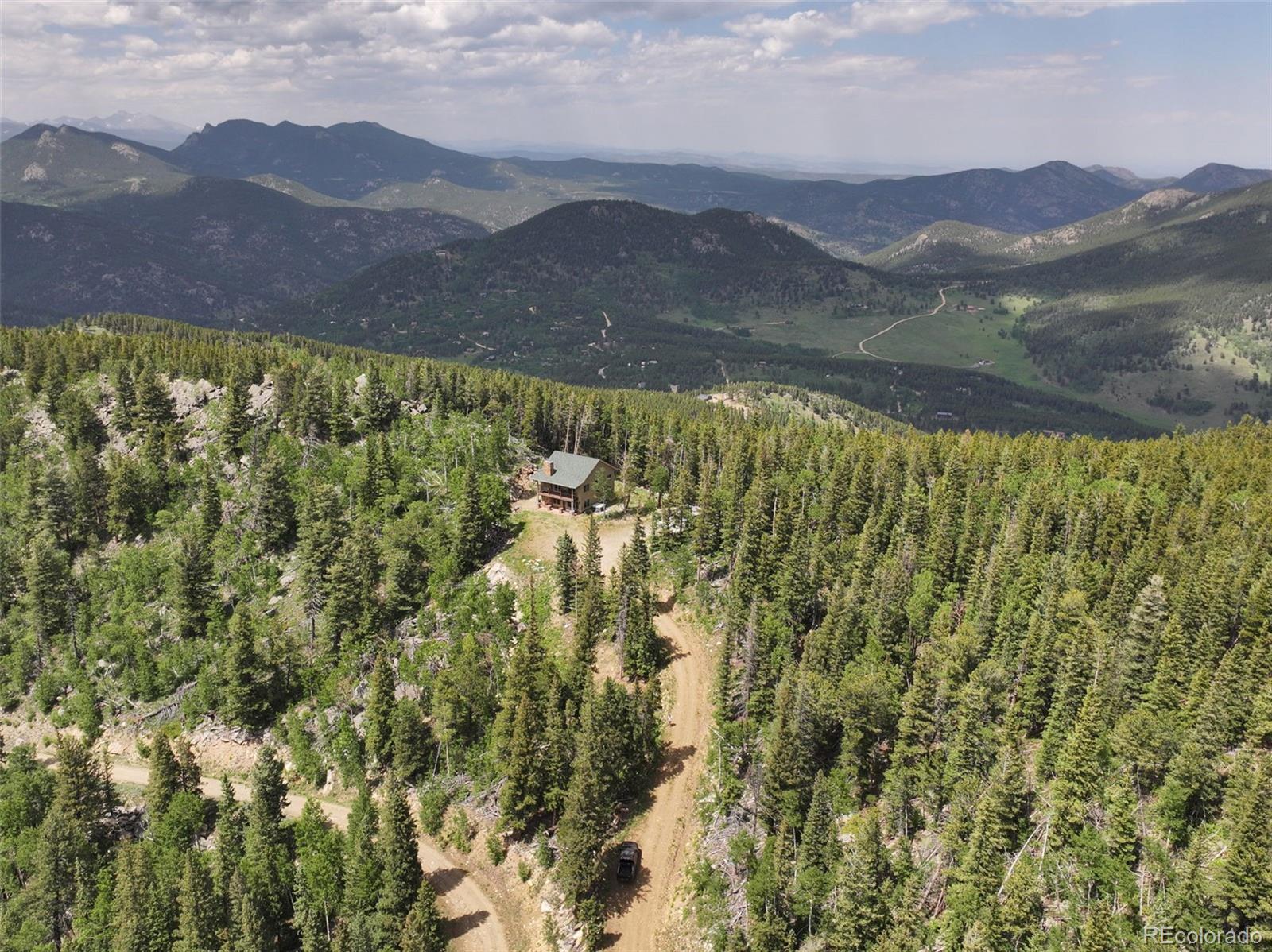 1555 Three Peaks Road Black Hawk, CO 80422 - Photo 11 of 50 a view of a lush green hillside and a mountain