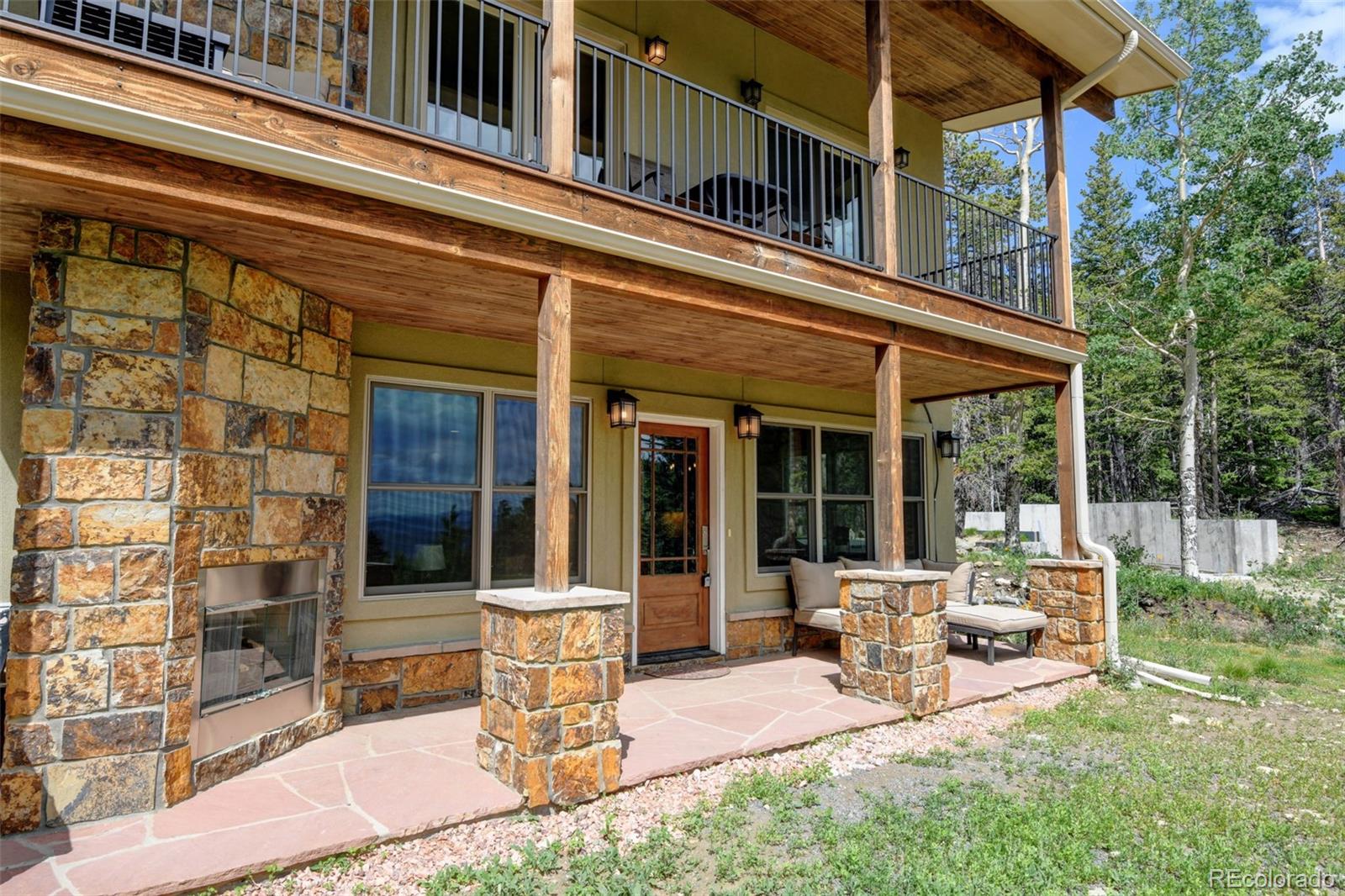 1555 Three Peaks Road Black Hawk, CO 80422 - Photo 15 of 50 a view of a house with backyard sitting area and porch