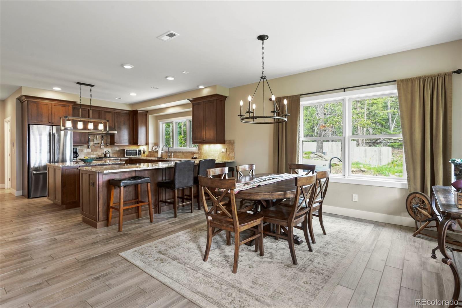 1555 Three Peaks Road Black Hawk, CO 80422 - Photo 18 of 50 a view of a dining room and livingroom with furniture wooden floor a chandelier