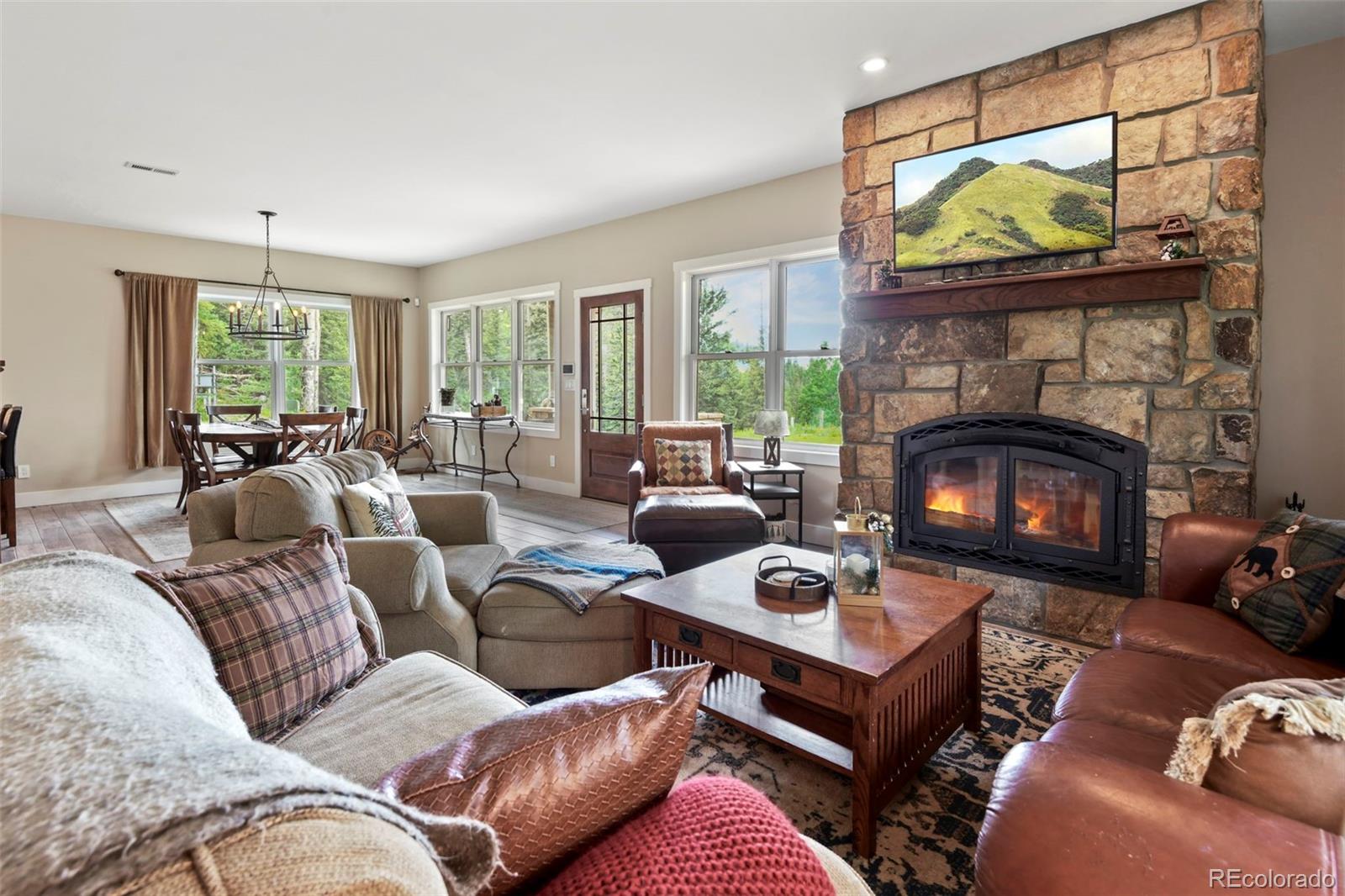1555 Three Peaks Road Black Hawk, CO 80422 - Photo 20 of 50 a living room with furniture a fireplace a flat screen tv and a large window